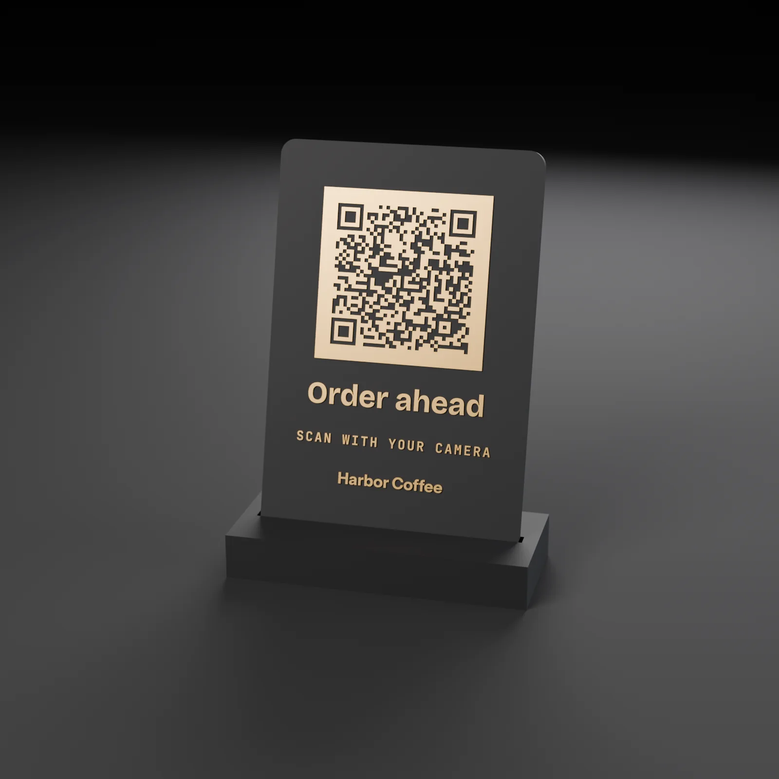 A charcoal QR order sign seated in a low base: a raised gold QR code above Order ahead, Scan with your camera and Harbor Coffee in gold.